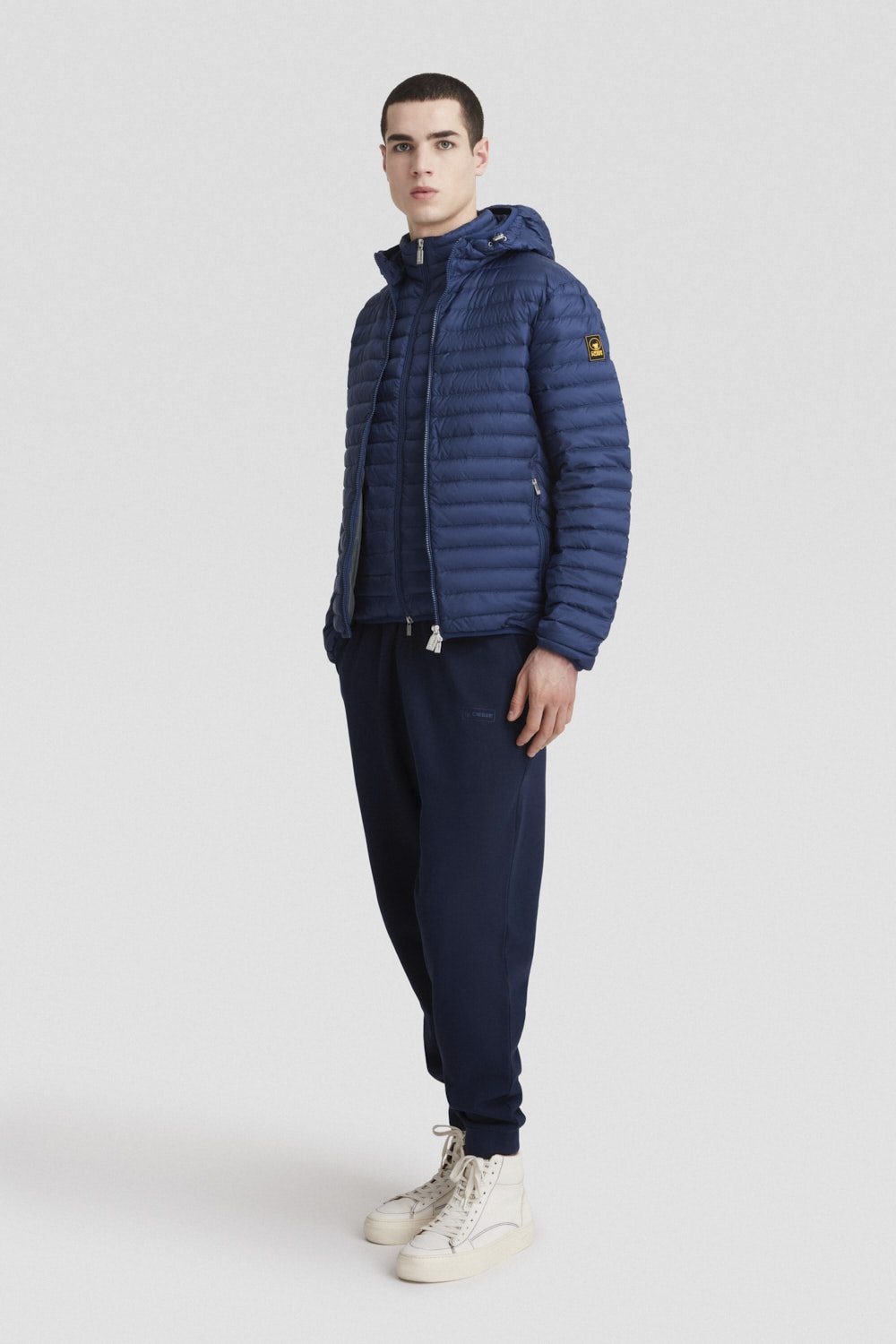 Piumino blu leggero opaco con cappuccio in vera piuma